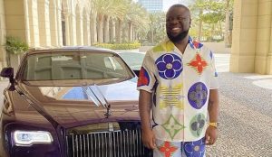 Hushpuppi picture smiling standing next to car